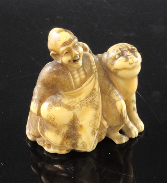 A Japanese walrus ivory netsuke of Binzuru Rakan and a tiger, Meiji period, 4.1cm